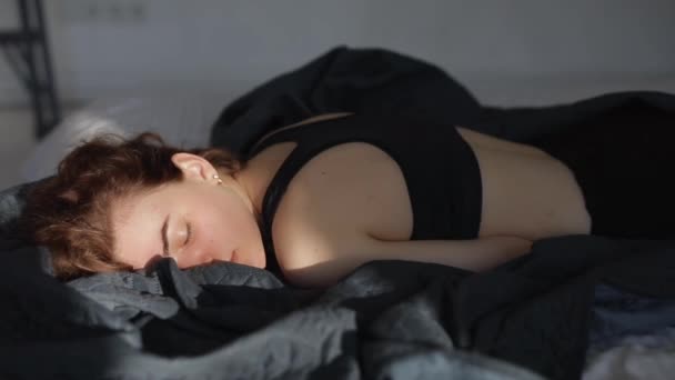 Mujer acostada en una cama abre los ojos — Vídeos de Stock