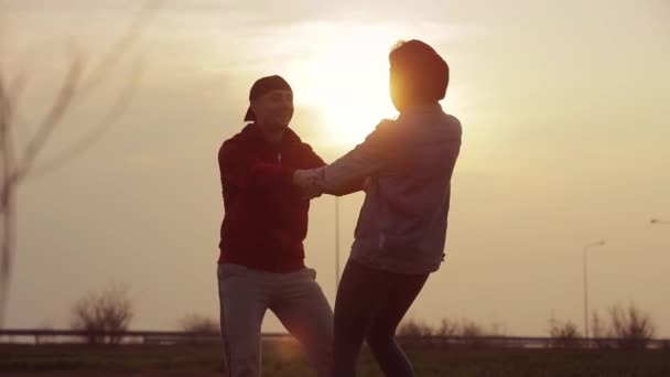 Silueta de pareja girando de la mano al atardecer — Vídeos de Stock