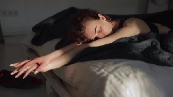 Tôt le matin, mignonne femme se réveille dans un lit — Video