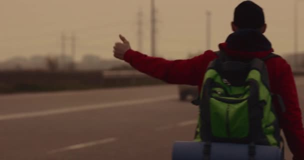 Турист едет по дороге ловит автомобиль — стоковое видео