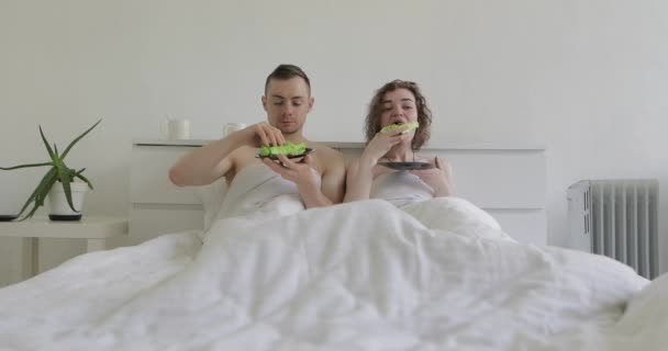 Casal comer comida em uma cama — Vídeo de Stock