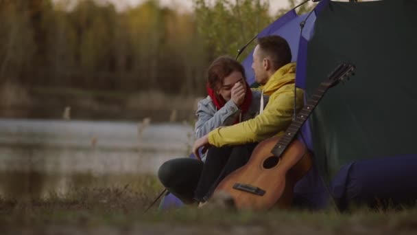 Par som kopplar av tillsammans i ett lägertält — Stockvideo