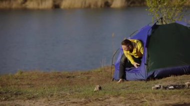 Kamp yapan adam sabah çadırda uyanır.