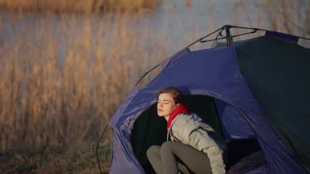 Кемпинг женщина просыпается в палатке по утрам — стоковое видео