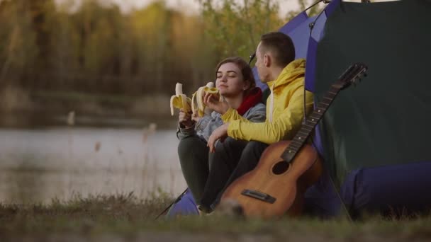 Casal comendo bananas em uma tenda de acampamento — Vídeo de Stock