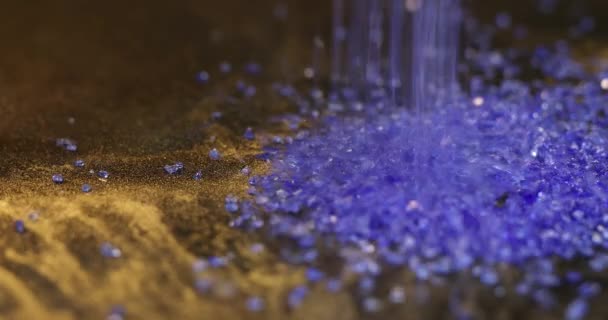 Strooi blauw saffier materiaal op zwarte achtergrond — Stockvideo