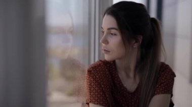 Pencereden bakan üzgün kadın