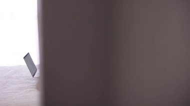 Dizüstü bilgisayarla çalışan bir kadın yatakta oturuyor.