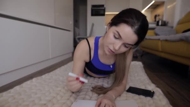 Sportowa kobieta robi notatki w domu — Wideo stockowe