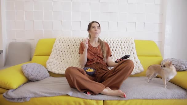Kobieta je chipsy siedząc w domu — Wideo stockowe