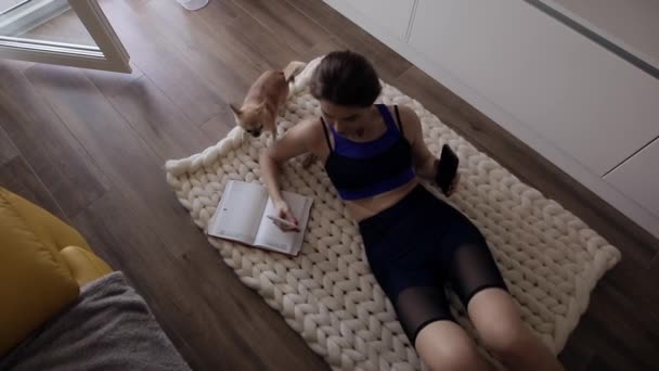 Femme sportive prendre des notes à la maison — Video