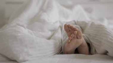 Yatakta sevişen bir çift. Çerçevede sadece ayak var. Aşk, seks konsepti.