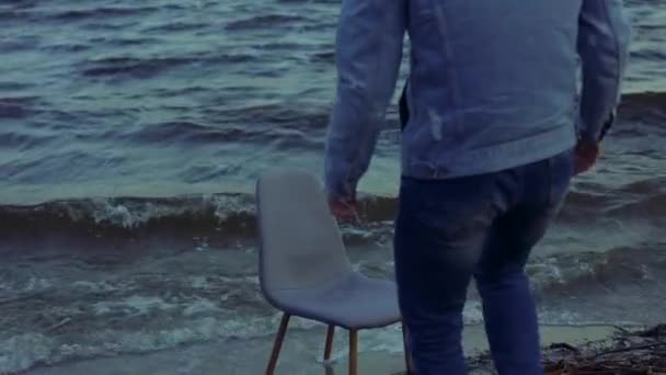 Alone man sitting on chair in a stormy sea waves — Stock Video