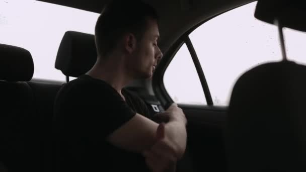 Чоловік кріпиться ремінь безпеки в машині — стокове відео