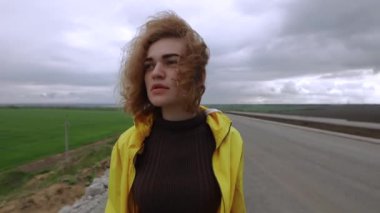 Bulutlu bir günde doğanın üzerinde duran kadın portresi