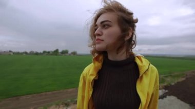 Bulutlu bir günde doğanın üzerinde duran kadın portresi