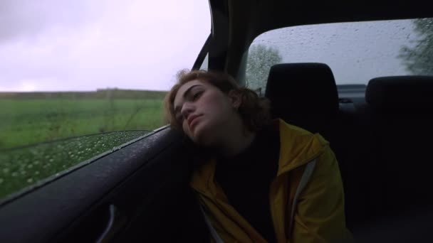 La mujer relajada mira a través de la ventana en un coche — Vídeos de Stock