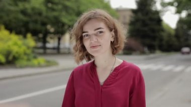 Şehir caddesinde kameraya bakan güzel bir kadının portresi.