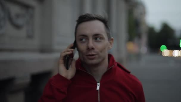 Homme parlant par smartphone marchant dans une rue de la ville — Video