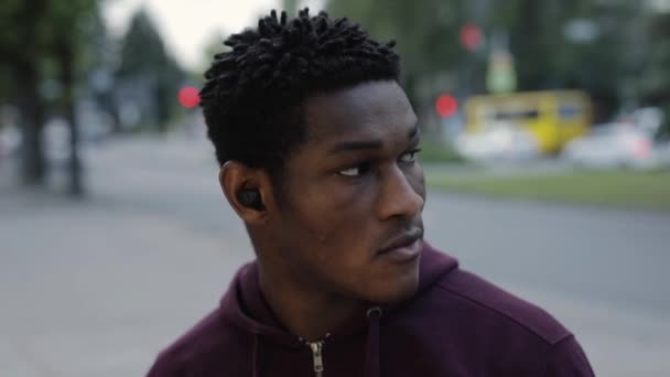 Zelfverzekerde Afro-Amerikaanse man die muziek luistert in oortelefoons — Stockvideo