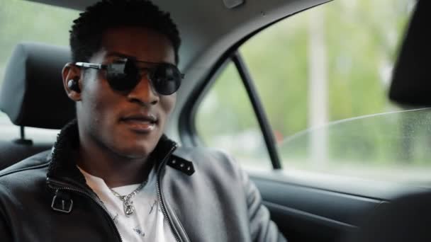 Cool Afro-Amerikaanse man luisteren muziek zitten in een auto — Stockvideo