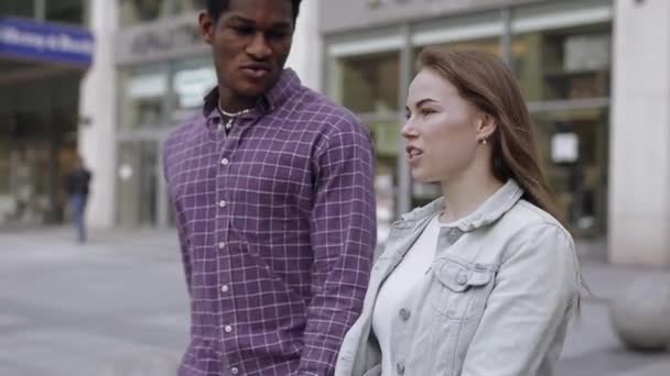 İki çok ırklı arkadaş şehirde yürüyor ve konuşuyor. — Stok video