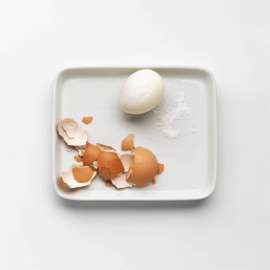 Beyaz bir tabakta, arka planda kaynamış yumurta.. 