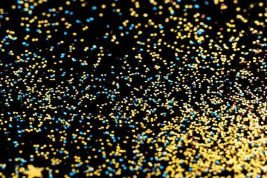 Şenlikli soyut parıltı dokusu. Koyu arkaplanda renkli ışıltılar. renkli konfeti. 