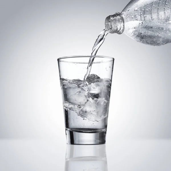 Gießen Von Wasser Glas Mit Spritzer Auf Weißem Hintergrund — Stockfoto