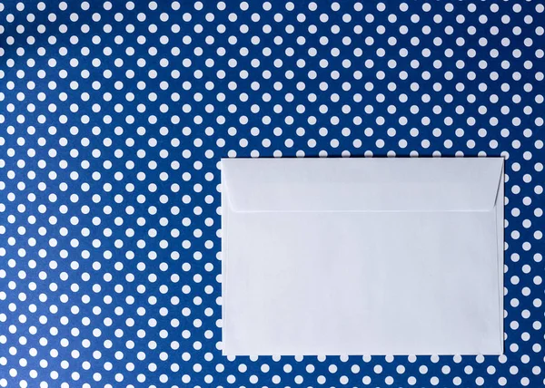 Envelope de papel branco em um fundo azul bolinhas ponto . — Fotografia de Stock