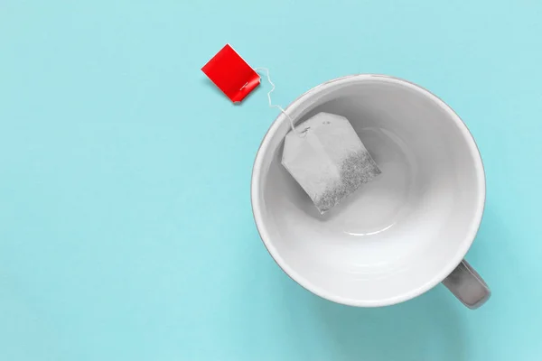Xícara vazia com saco de chá de papel — Fotografia de Stock