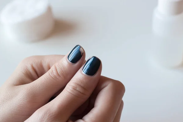 Eski karanlık mavi manikür. Eski püskü tırnak cilası. Beyaz masaya eller kadın. Spa.
