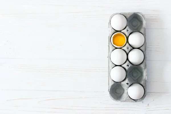 Ambalaj Yumurta Beyaz Ahşap Zemin Üzerinde Kırık Yumurta Sarısı Ile — Stok fotoğraf