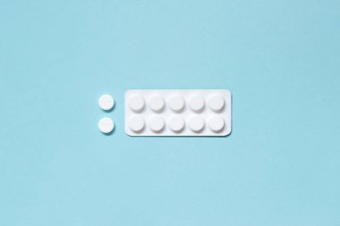 Beyaz blister ve hap mavi bir arka plan üzerinde. İlaçlar