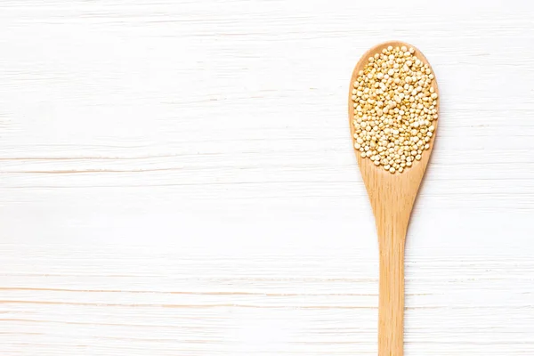 Beyaz Quinoa tohumlar Beyaz ahşap masa üzerinde tahta kaşıkla. Sağlıklı bir diyet kavramı. Süper yiyecek.