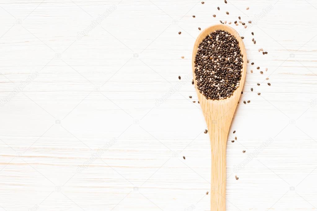 Wooden spoon with Chia seeds on white wooden table. Concept of a healthy diet. Super food.
