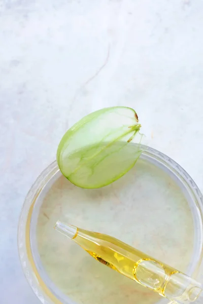 Pipette üzüm tohumu yağı ve bir dilim üzüm çileği. Saf essenti.