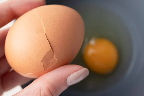 A nő barna törött organikus tojást tart, felülnézetből. Készítek egy... — Stock Fotó
