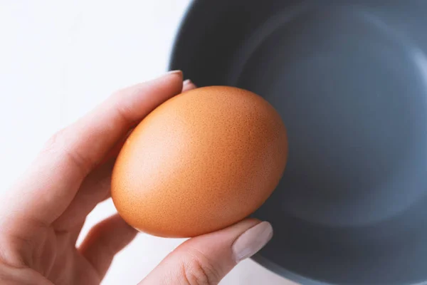 Kadın eli kahverengi organik yumurtayı tutuyor. Yapacağım. — Stok fotoğraf