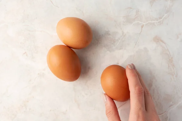 Kadın Eli Kahverengi Organik Yumurtaları Mermer Arka Planda Tutuyor Tavuklu — Stok fotoğraf