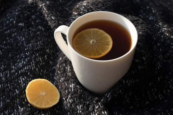 Chá preto com fatia de limão na xícara branca no backg de camisola de malha — Fotografia de Stock
