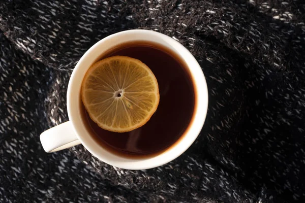 Nahaufnahme schwarzer Tee mit Zitronenscheibe in weißer Tasse auf Hintergrund — Stockfoto