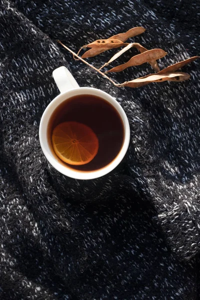 Té negro con rodaja de limón en taza blanca sobre fondo de punto — Foto de Stock