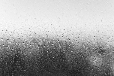 Condensation drop on glass, close-up. Black and white defocused  clipart