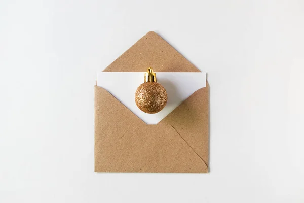 Boule de paillettes dorées de Noël sur enveloppe en papier avec lette vierge — Photo
