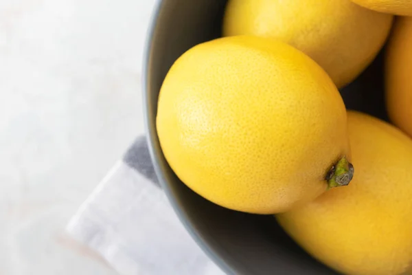 Close-yp friss sárga citrom tálban és törölköző márvány asztalon, t — Stock Fotó