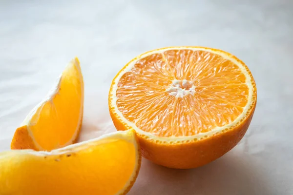 Die Hälfte der Orange aus nächster Nähe betrachten und auf einer hellen Tischfläche in Scheiben schneiden. frisch — Stockfoto