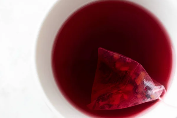 Detail čaj pyramida pytel s ovocným čajem v bílém hrnku na bílém b — Stock fotografie