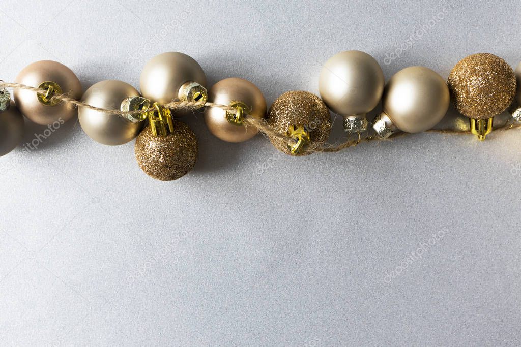 Top border modern Christmas golden balls on shiny silver backgro