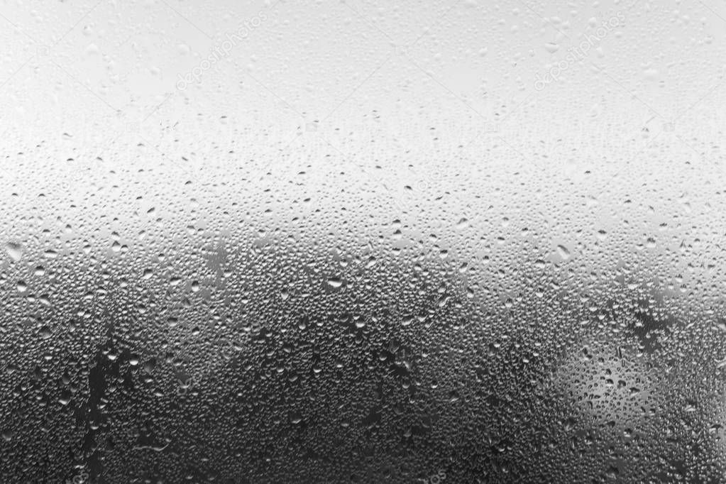 Condensation drop on glass, close-up. Black and white defocused 